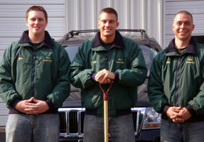 Three members of the New England Tree Experts snow crew in uniform